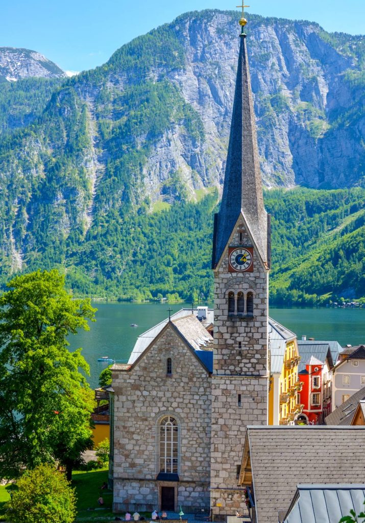 church in hallstatt austria with the lake below and mountains behind