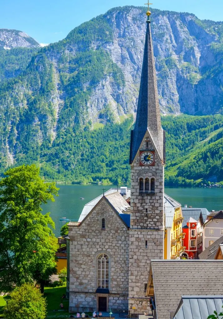 church in hallstatt austria with the lake below and mountains behind