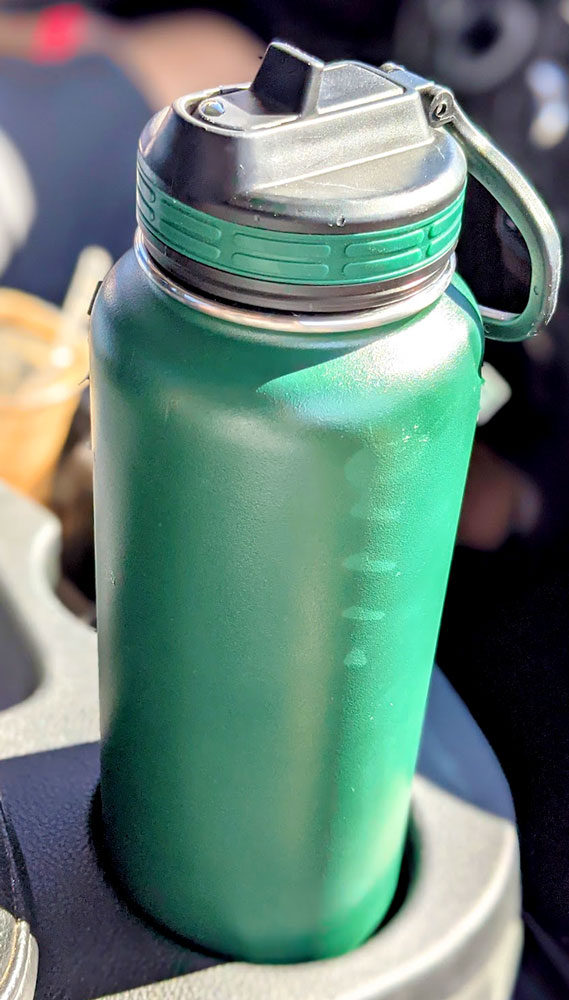 1.2 litre green thermoflask water bottle with a handle and a straw spout magically fitting in a cup holder