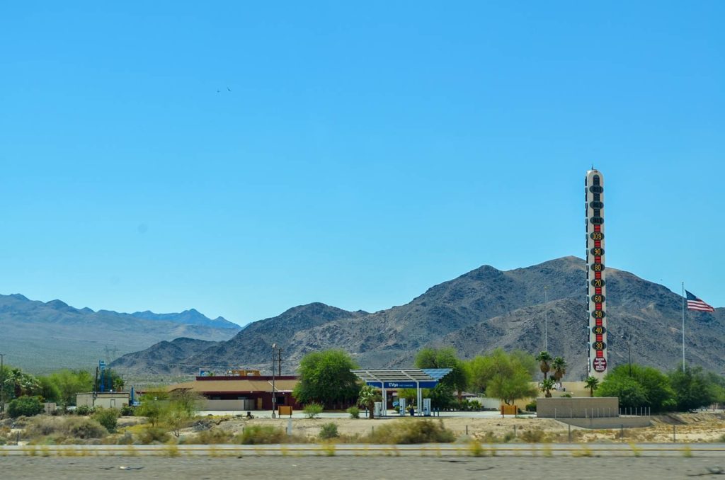 the giant thermometer from the road towering above the mountain in the background on the drive to vegas from los angeles