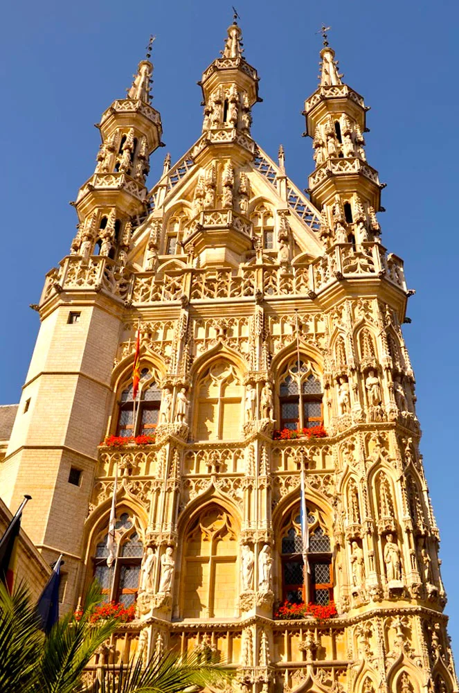 a soaring gothic tower in a blank blue sky. The building is so intricate that it's good there's nothing else in the photo. It has three towers, but many windows, and even more designs going across the tower that you can stare at it for hours noticing all the small architecture choices.