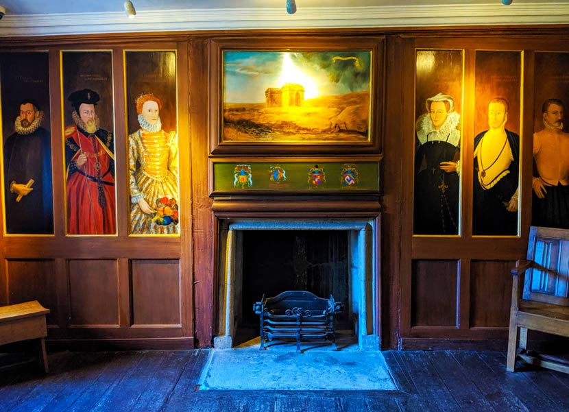 inside mary queen of scots house in Jedburgh. This room has narrow and tall painted portraits of the key Scottish players during the time, including Mary Queen of Scots. There's are three portraits on either side of a fireplace