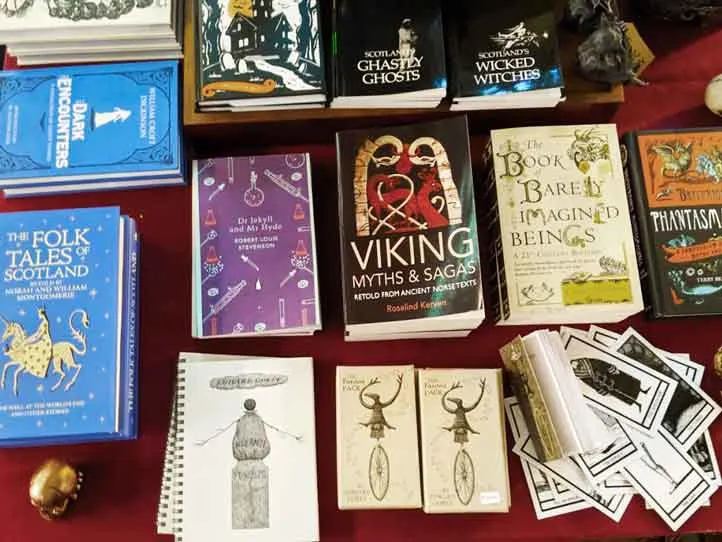an overview picture of books lying flat on a table so you can see the covers for scotland souvenirs. Titles like the folks tales of scotland, viking myths and sagas, the book of barely imagine beings, and Scotland's wicked witches.