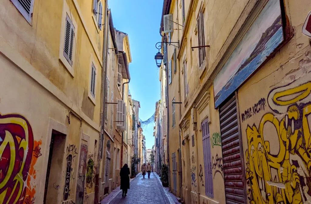 sketchy-graffitied-alley-way-in-panier-marseille-with-people-walking-through-it