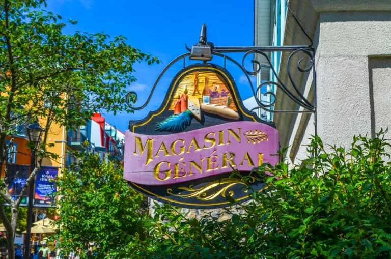 close up of the magasin general store sign hanging out from the building in an old school style
