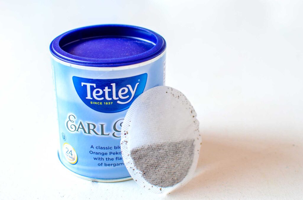 A simple photo displaying the round tea tin for tetley earl grey tea. It's a blew label. You understand how the tin is round, because there's an individual tea bag resting on the tin, and it's a circular tea bag. 