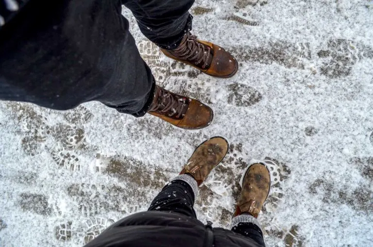 look from above legs and boots with snow on the ground
