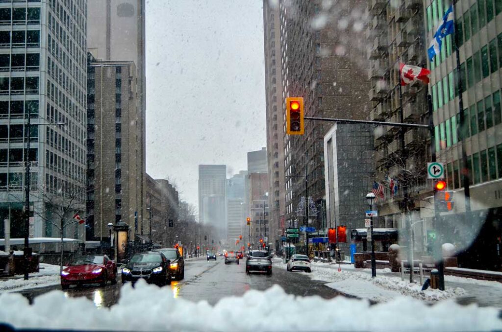 downtown montreal while snowing cars on the road, stopped at a light