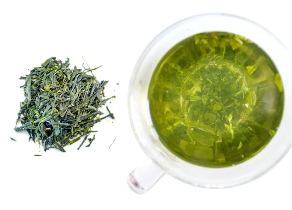 side by side comparison of the dry gyokuro Japanese tea leaf and the steeped tea in a doubled walled glass mug, and you can see the wet leaves on the bottom. 
The left is the dry leaf, a beautiful evergreen, they are small pieces, and narrow. The steeped is a rich more army green. 