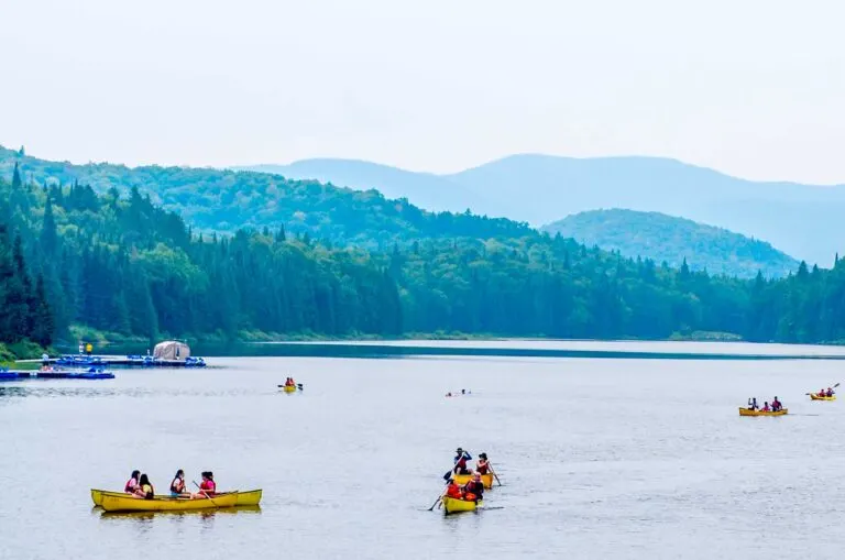 6 yellow canoes on the lake at mont tremblant national park near montreal with a haze over the mountains in the distance