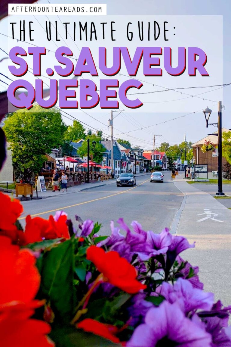 Pinnable Image: the ultimate guide to St. Sauveur Quebec view of Rue Principale street during the day in the summer with clear skies, flowers lining the streets, people are walking on the sidewalks