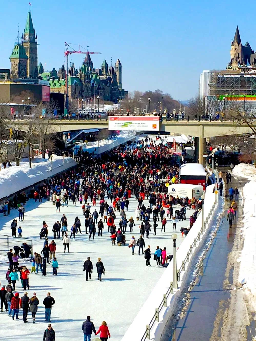 ottawa winterlude festivals near montreal. The view of the rideau canal in winter when it's open for skating. Rideau section, so you can see both parliament and the edge of the chateau laurier fairmont hotel. The rideau canal is open, and it's packed. You can barely see individual people it's so densely packed, especially near the stairs leading off the ice. 