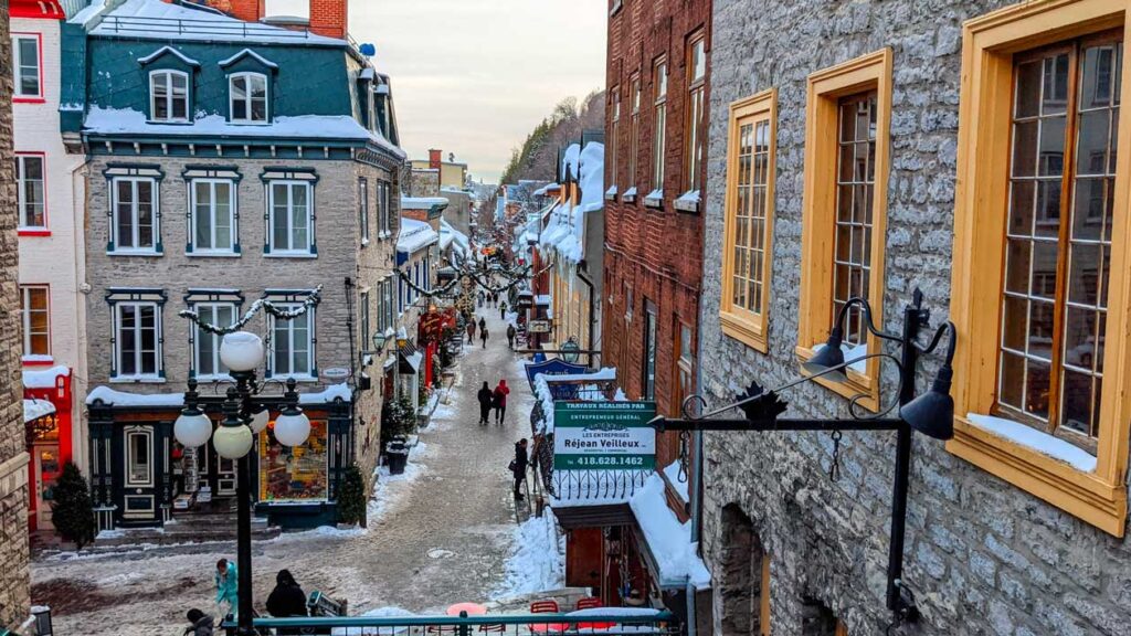 rue-du-petit-champlain-in-the-snow-you-see-all-the-way-down-the-street-with-stone-walled-shops-and-lights