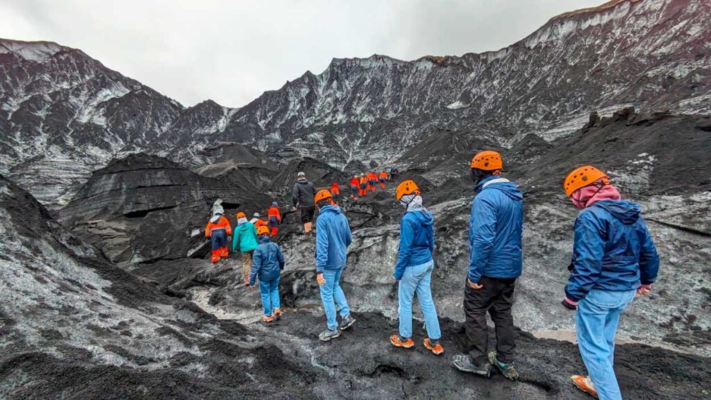 people-walking-on-a-ash-glacier-in-Iceland