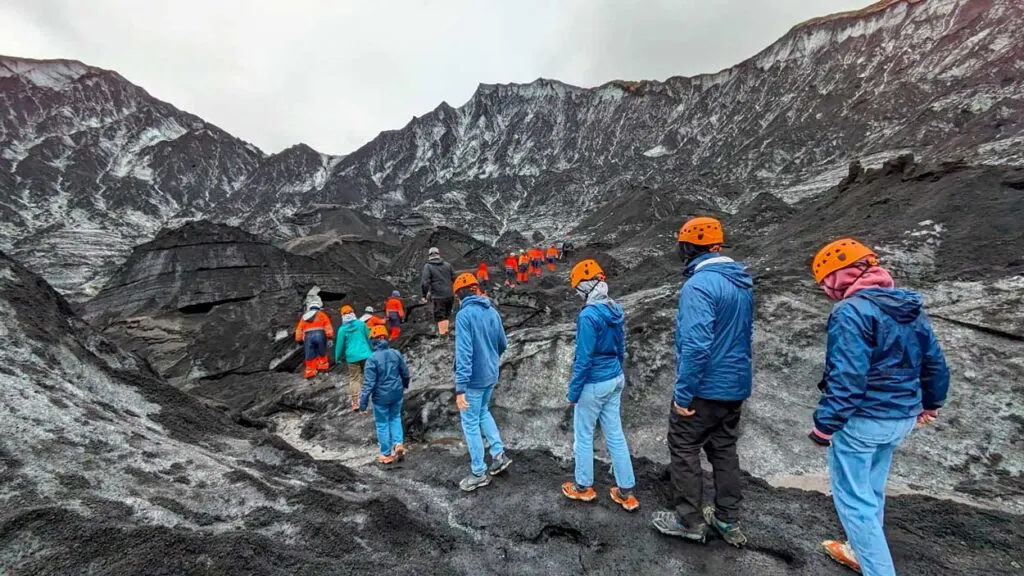 people-walking-on-a-ash-glacier-in-Iceland