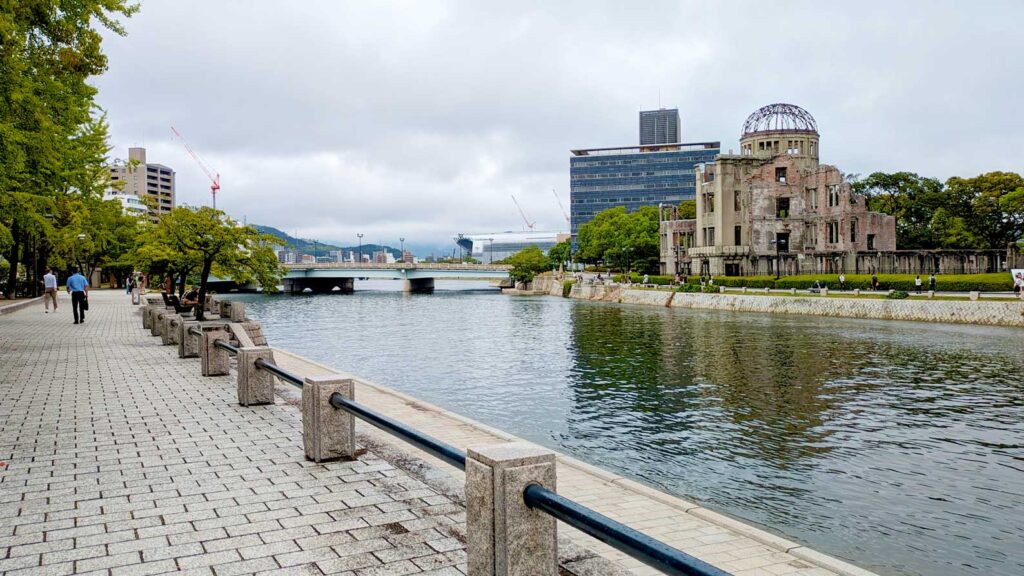 hiroshima atomic bomb dome across the river leading off into the distance. It's a completely overcast day, looking like it's about to rain - the perfect setting for seeing hiroshima in japan