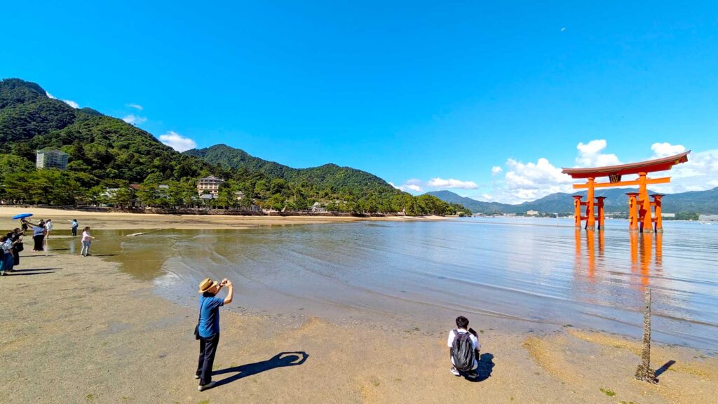 low tide at the otorii gate.  You can see most of the pillars, and people are standing on the shore, all photographing the otorii gate