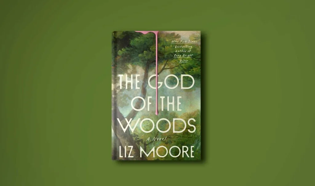 a green background with a book in the middle. The cover of the book is a green painted wooded scene with a large tree in the foreground. The title is: The God of the Woods A Novel by Liz Moore. There's also a very fake, pink, almost gummy looking, drip of what is supposed to be blood coming from the top. 