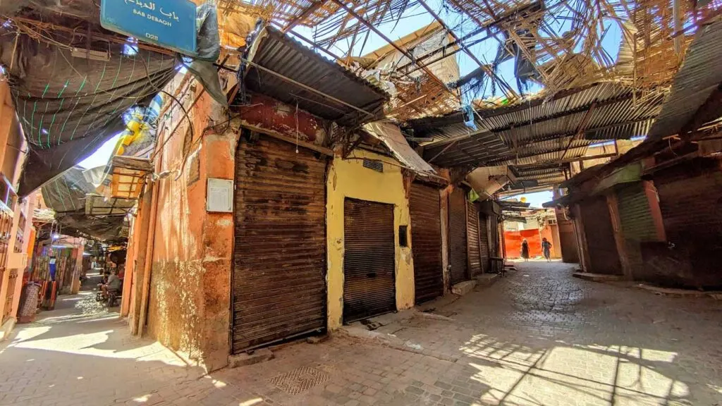 the less than ideal areas of walking through the market in marrakech. you can see two alleys, but both don't look great.The fabric roof is completely ripped up, which at least lets in some natural sunlight making it feel less terrifying.