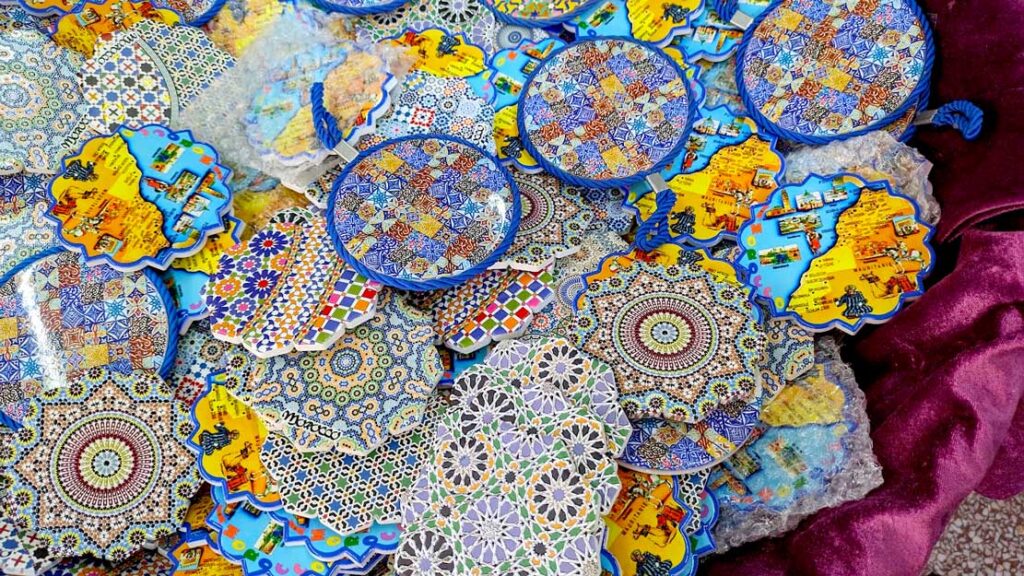 an example of zellige coasters you could buy in Morocco as a souvenir. There are three different types of moroccan tile patterned coasters in a large display table