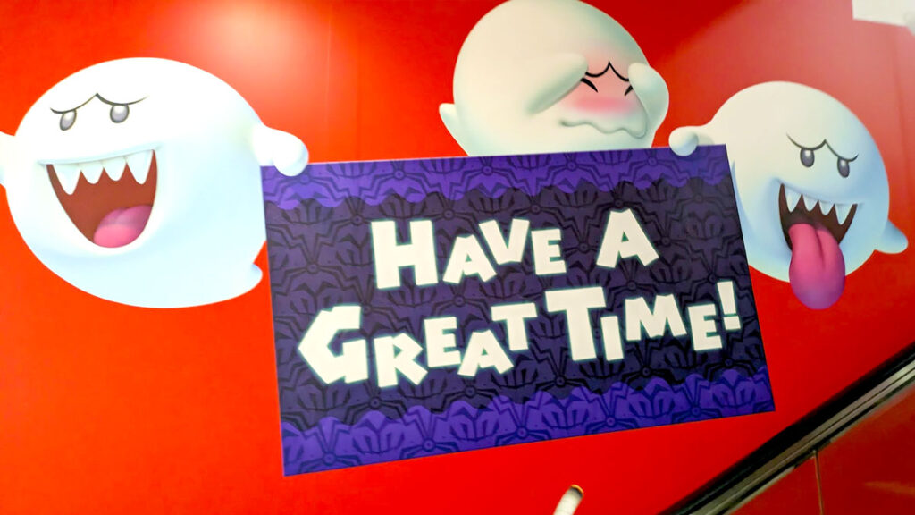 a mural of three mario King Boo on a red backgorund. They are holding a sign that says: have a great time!