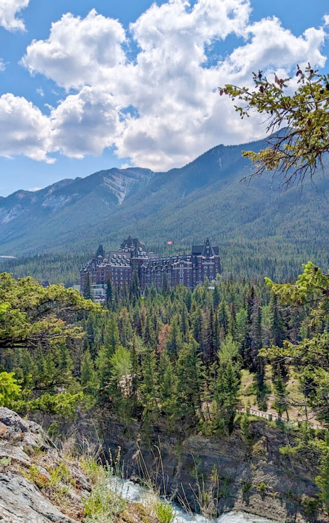 a brown chateau hidden amongst the trees of the mountains in the Canadian rockies. 