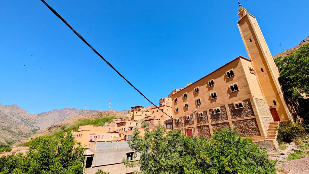 A black wire leads your eye from the left to the right all the way to a mosque on the other side. Behind the yellow mosque is an entire village built into the side of the mountain. All the homes are very similar so they kind of blend into each other. The blue sky above adds a beautiful contrast.
