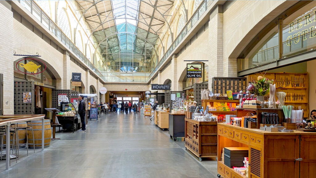 inside the ferry building in san francisco. It's a pretty glass domes ceiling letting in some natural light. Shops all line the indoor passage way on either side.