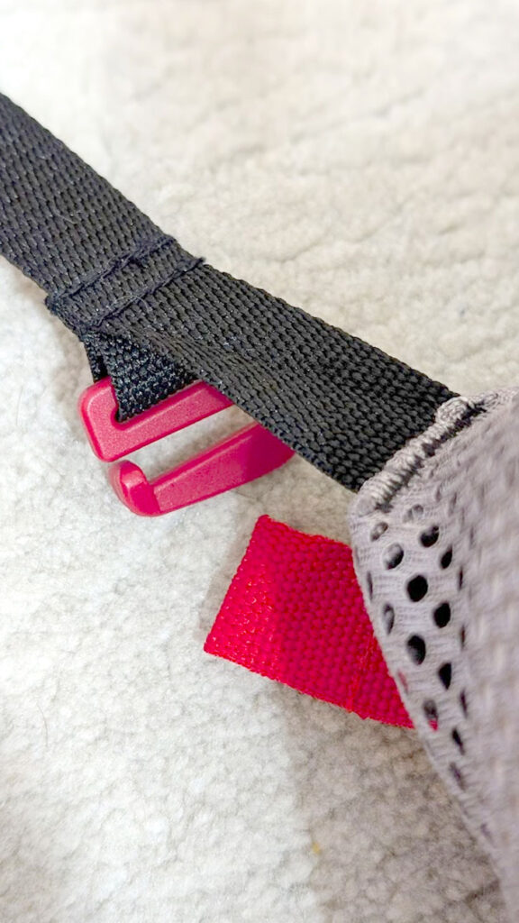 the red hook and loop that need to be attached from the babybjörn travel crib. 